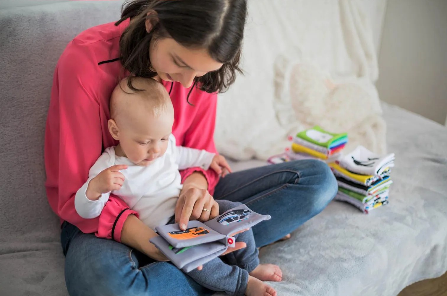 Mother holding her baby and reading a book