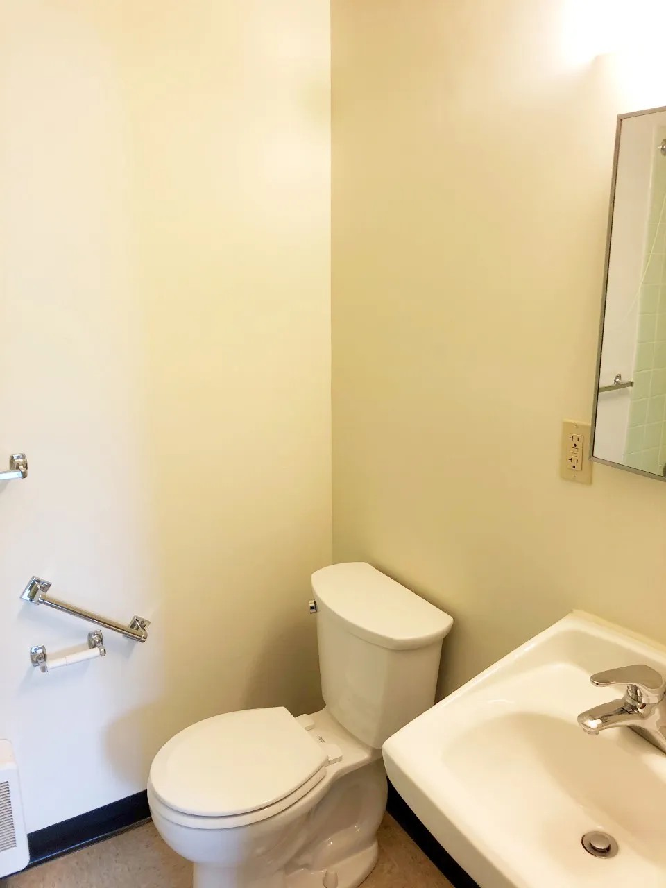Bathroom toilet and sink with accessible grab bars
