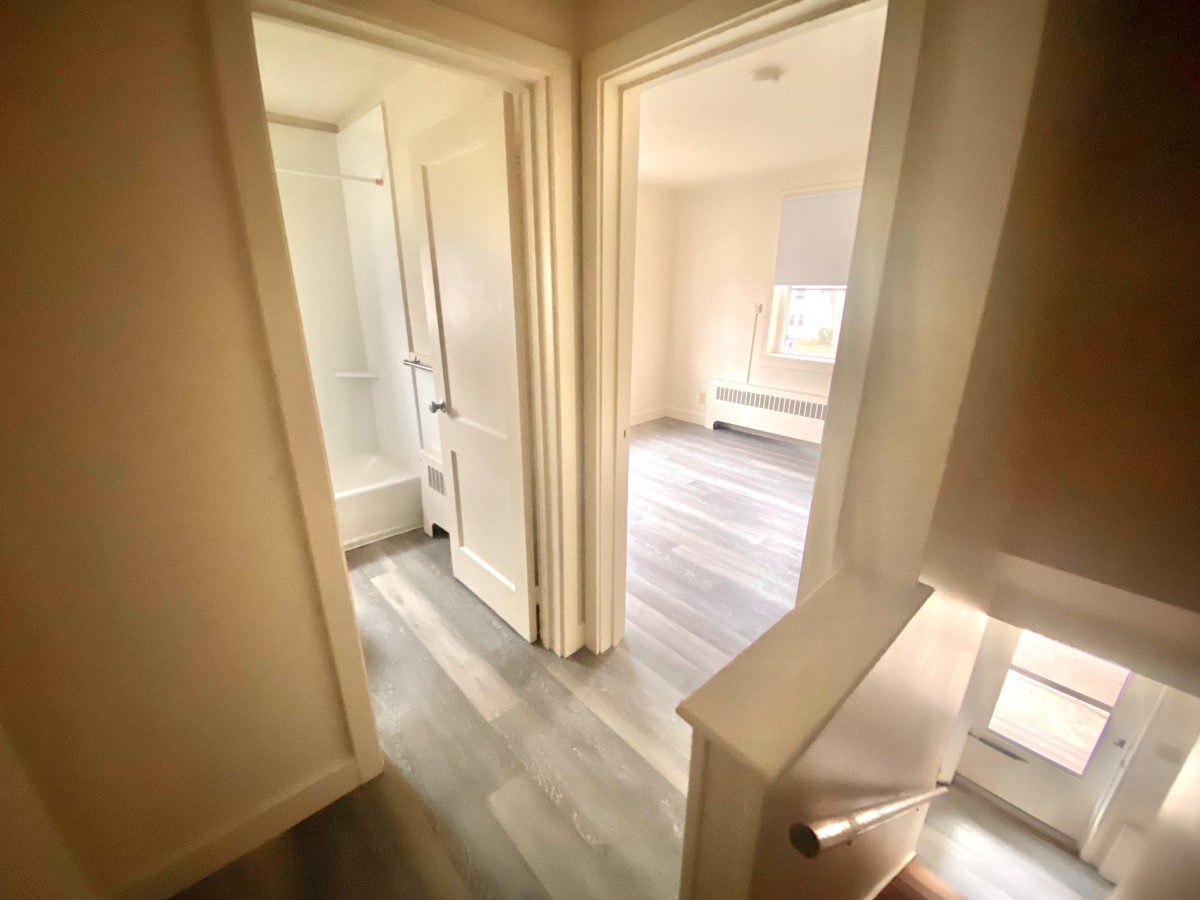 Landing area leading to bedroom, stairs, and bathroom