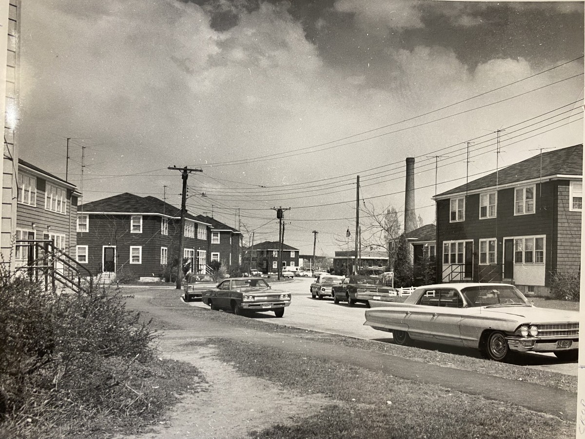 Historic view of apartments yard and street with parking