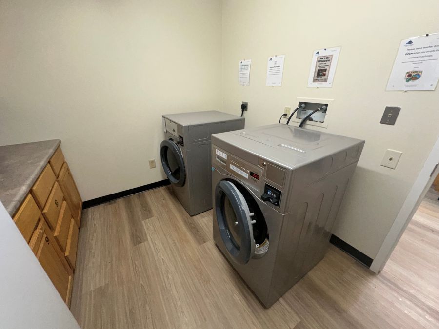 Laundry area with washers, dryers and counter tops with storage