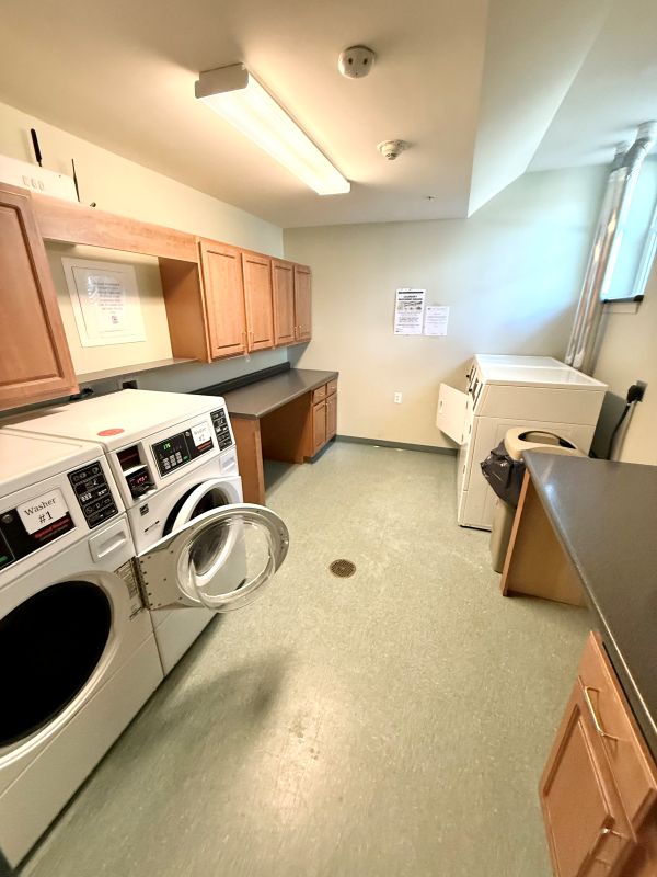 Laundry room with washers, dryers, counter space, and cabinets